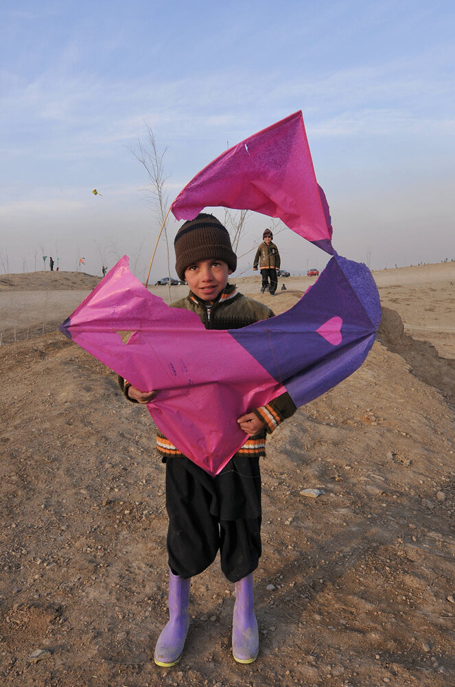   An Afghan boy shows his broken kite on a hill overlooking the city of Kabul, 11 January 2008. As with music and other forms of entertainment, kite flying was forbidden during the Taliban period.                                                      