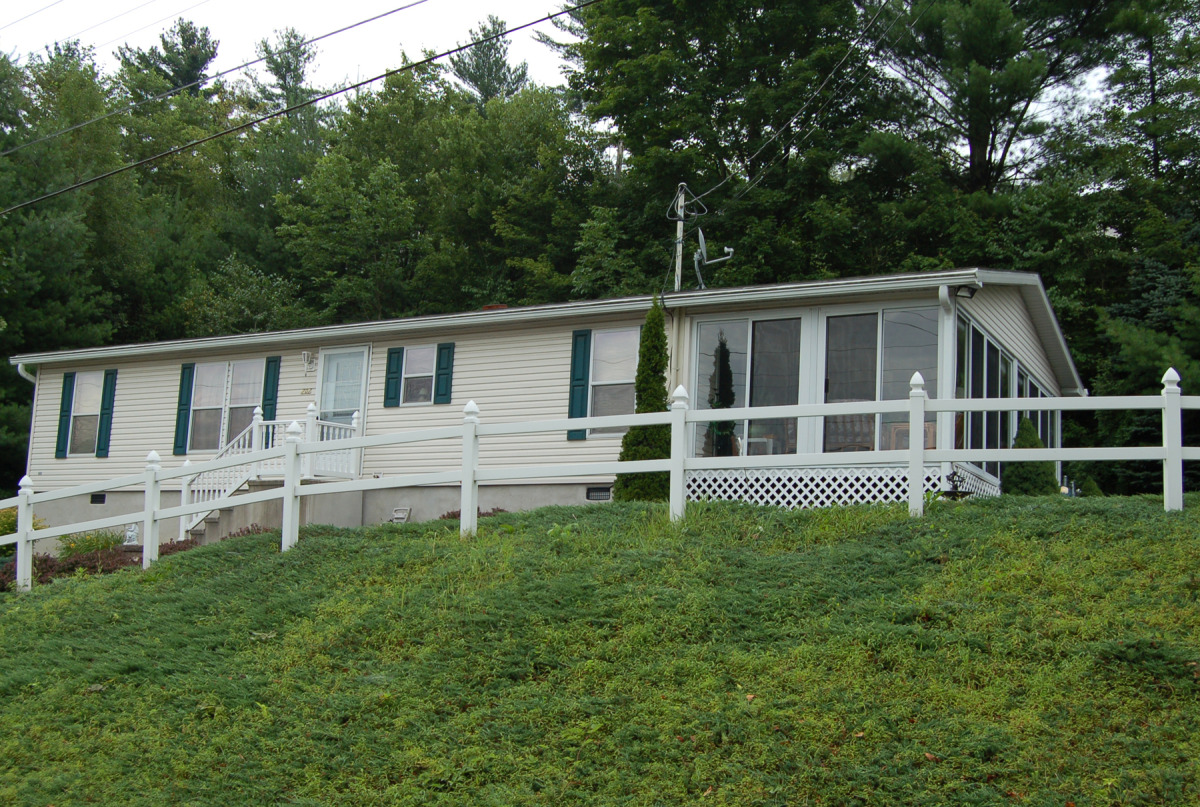 Manufactured Home On Concrete Crawlspace, Showing a Site Built Sunroom addition. View from Right Gable.
