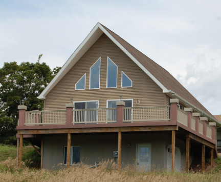 Exterior View from Gable end. Shows Spacious Wrap Around Composite Deck with planter boxes on each Newel Post.