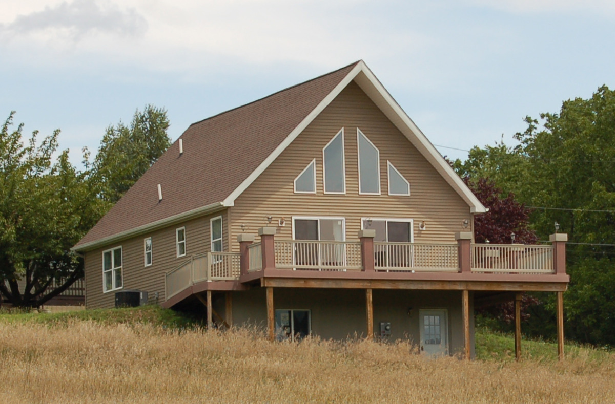 Exterior View of Gable end Showing the Wrap Around Composite Deck and Setting.
