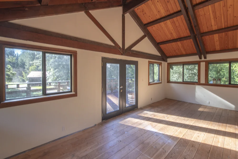 Open living space with beautiful wood beams, floors and windows.