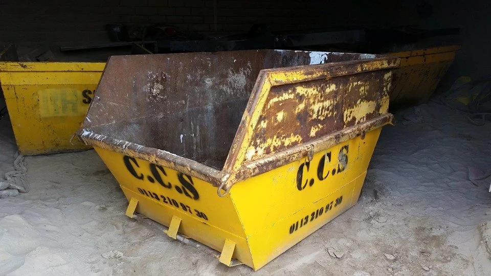 Rusted skip before sandblasting, heavy paint and corrosion visible