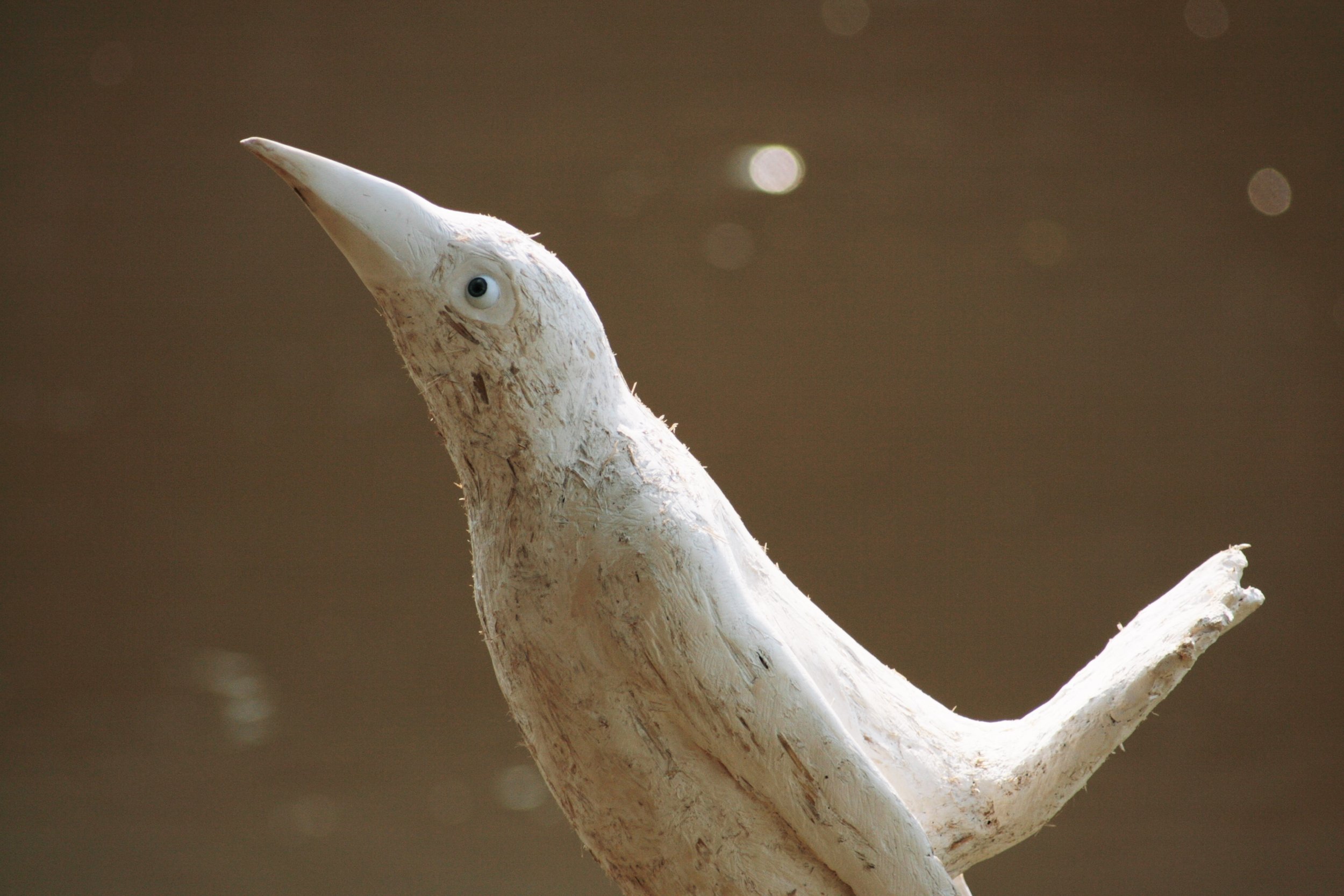 Close view of a pale plaster bird sculpture from Bristol Birds, installed beside the River Avon at Paintworks in Bristol.