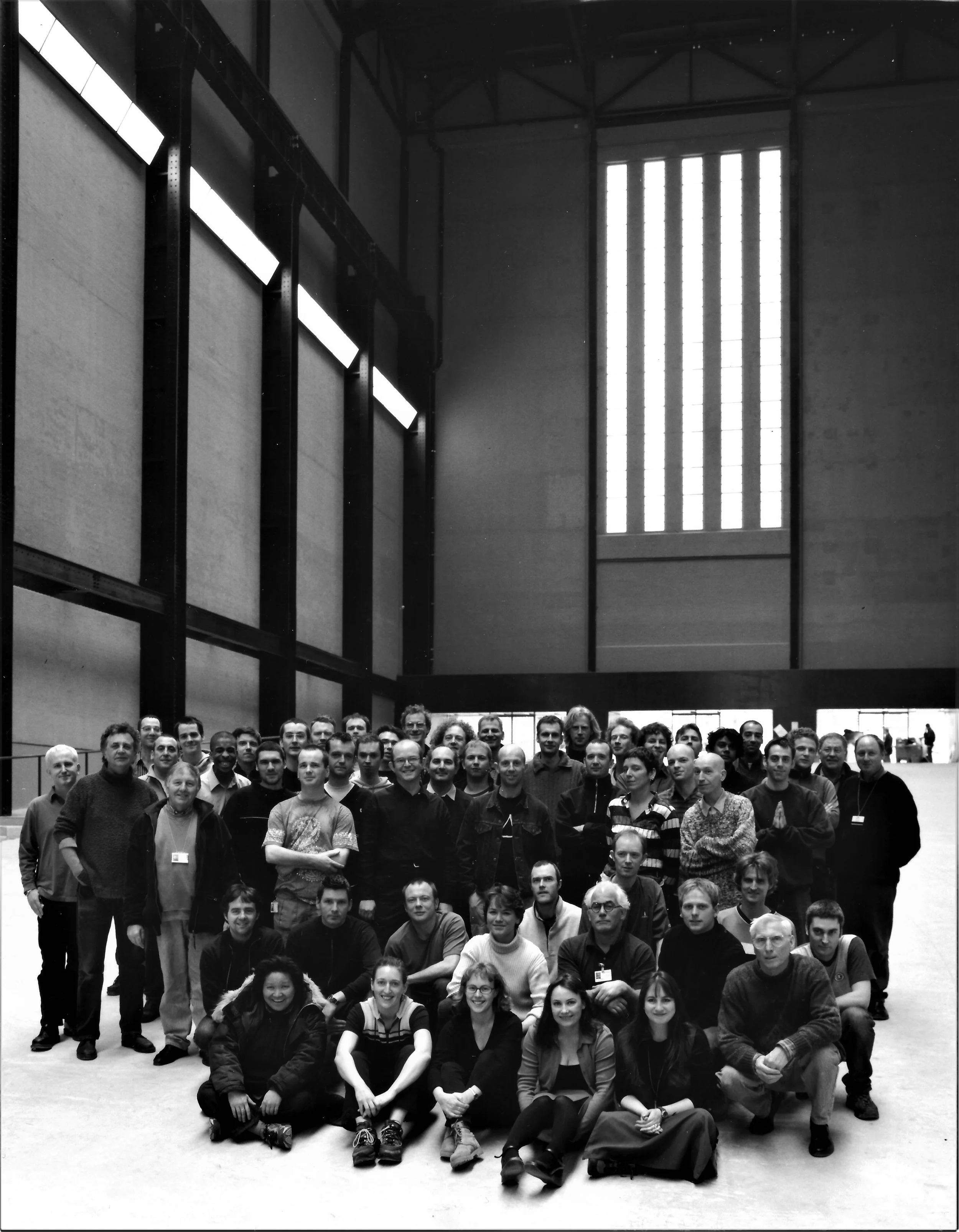 Black-and-white group photograph of the Art Handling and Registrars Department inside Tate Modern’s Turbine Hall in 2001.