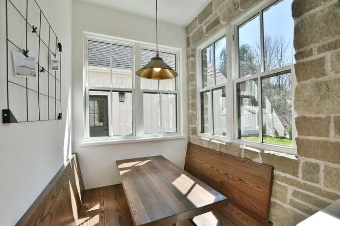 The breakfast nook, for more than just breakfast. 🥞 It's a perfect spot for crafts, coloring, cards and conversation. &clubs;️ It also keeps the kids or grandkids' mess contained. The stone on the wall and through the window is also a nice touch 👌

