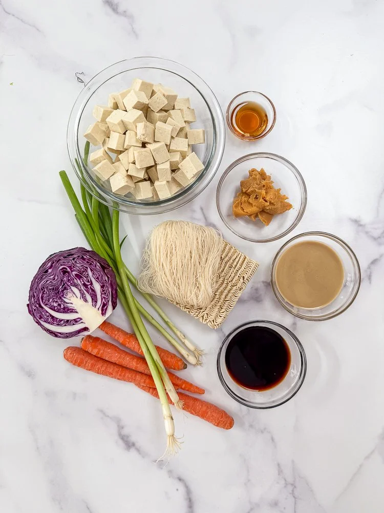 Top dow shot of ingredients for instant noodle ramen meal prep on marble counter.
