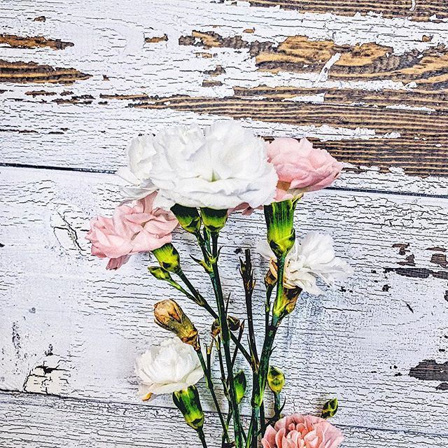 Behind the flowers is a distressed door by TAWC. (The Accent Wall Company)