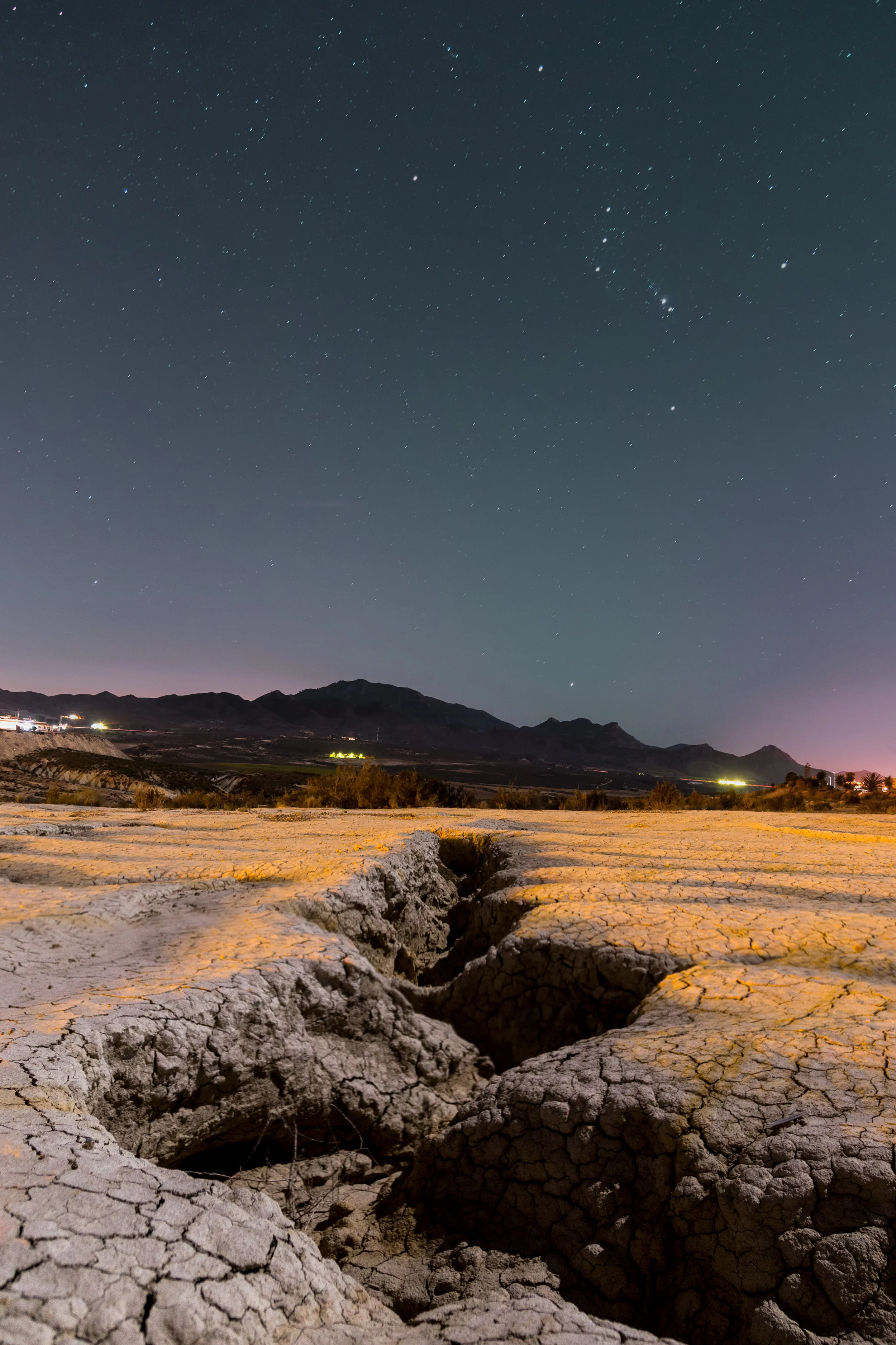 The constellation Orion looking over a desert water channel.