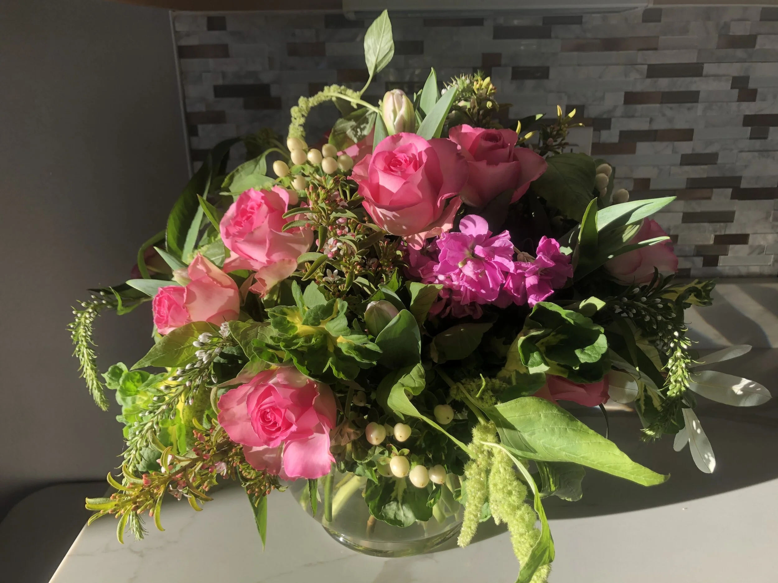 Lush floral arrangement with pink roses, hanging amaranthus and bold foliage by Snowdrops & Sage