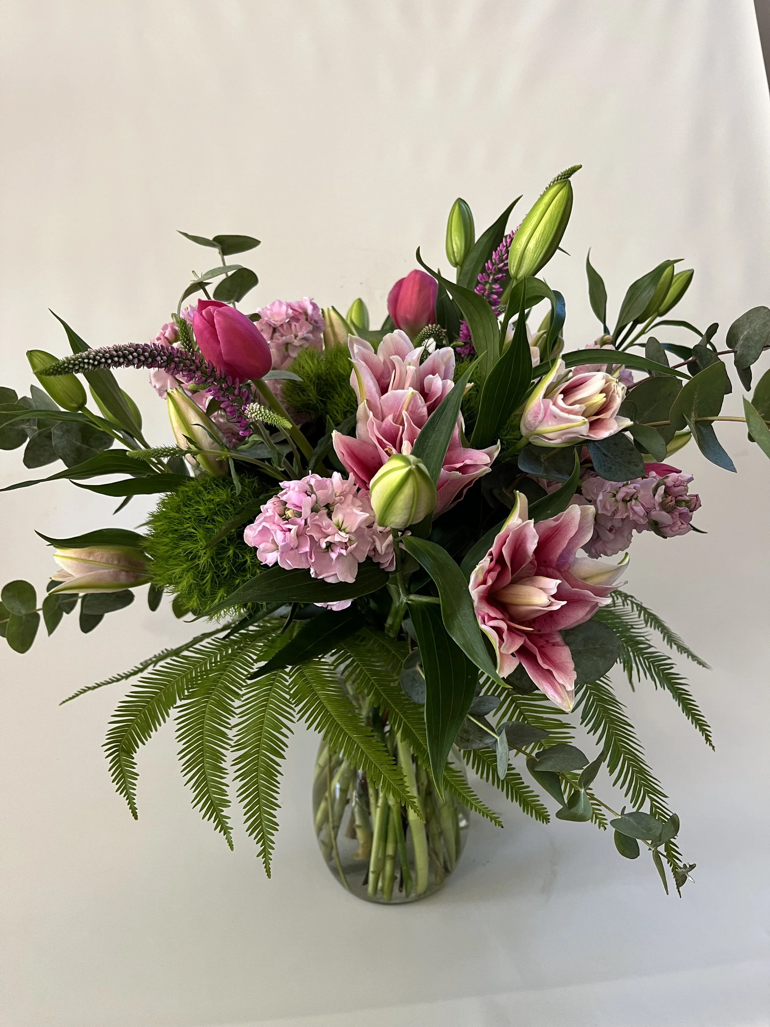 Elegant floral arrangement with pink rose lilies, gumdrop eucalyptus and imported tulips  by Snowdrops & Sage