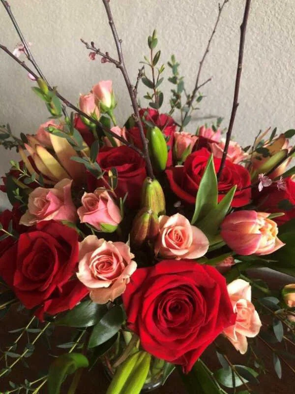 Lush signature holiday floral arrangement with red roses and greenery by Snowdrops & Sage