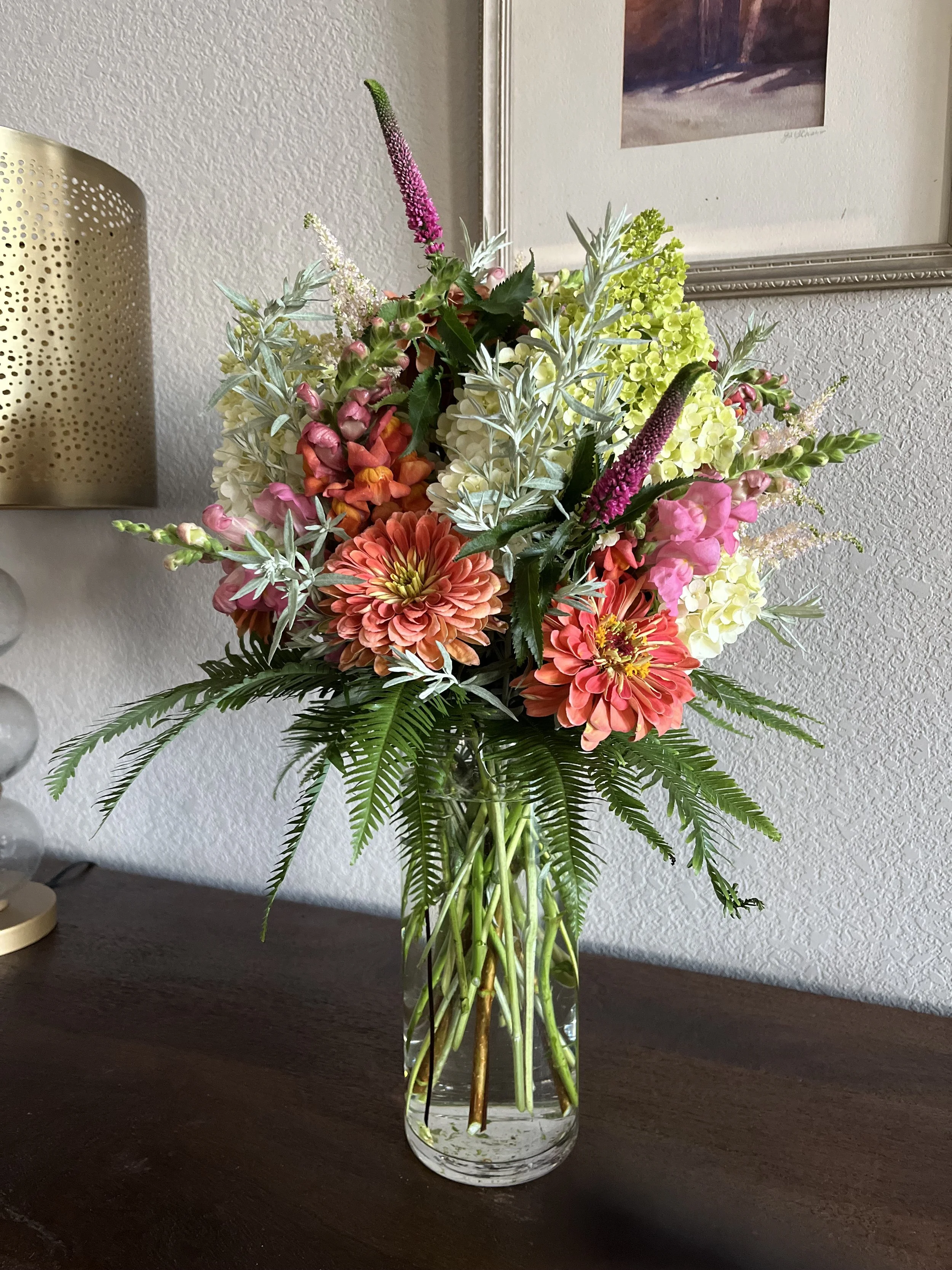 Vibrant bouquet, showcasing orange dahlias, pink snapdragons, and white hydrangeas by Snowdrops & Sage in Arvada, CO