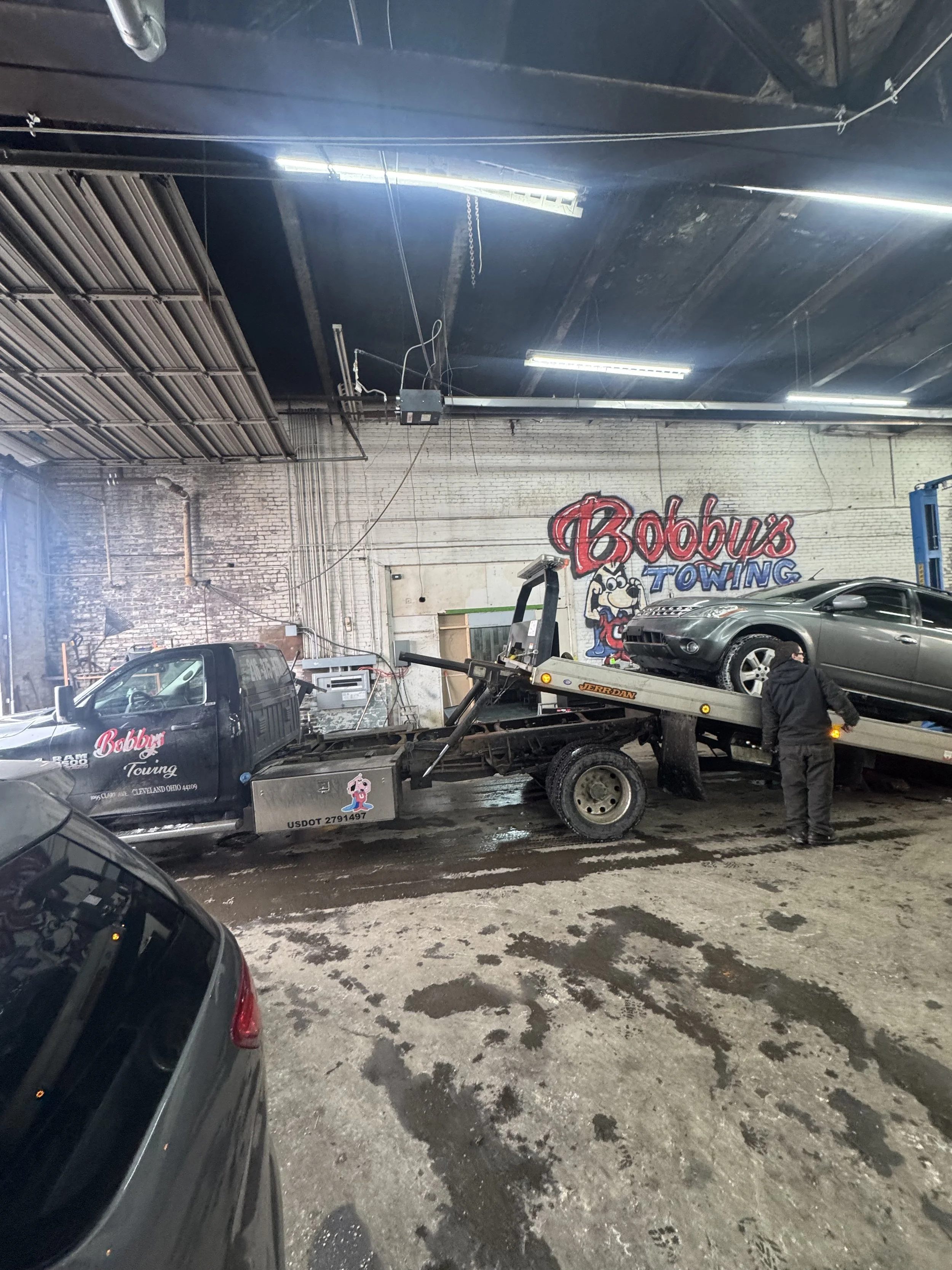 Flatebed tow truck with car on bed in Bobby's Towing building  Cleveland, OH