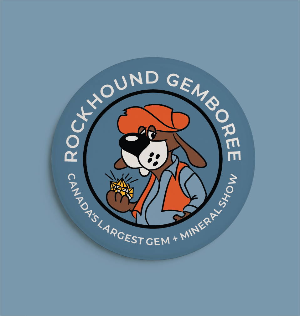 A circular logo for Rockhound Gemboree, featuring a cartoon dog wearing an orange hat and vest, holding a yellow gemstone. The text around the logo reads "Rockhound Gemboree" and "Canada's Largest Gem + Mineral Show."