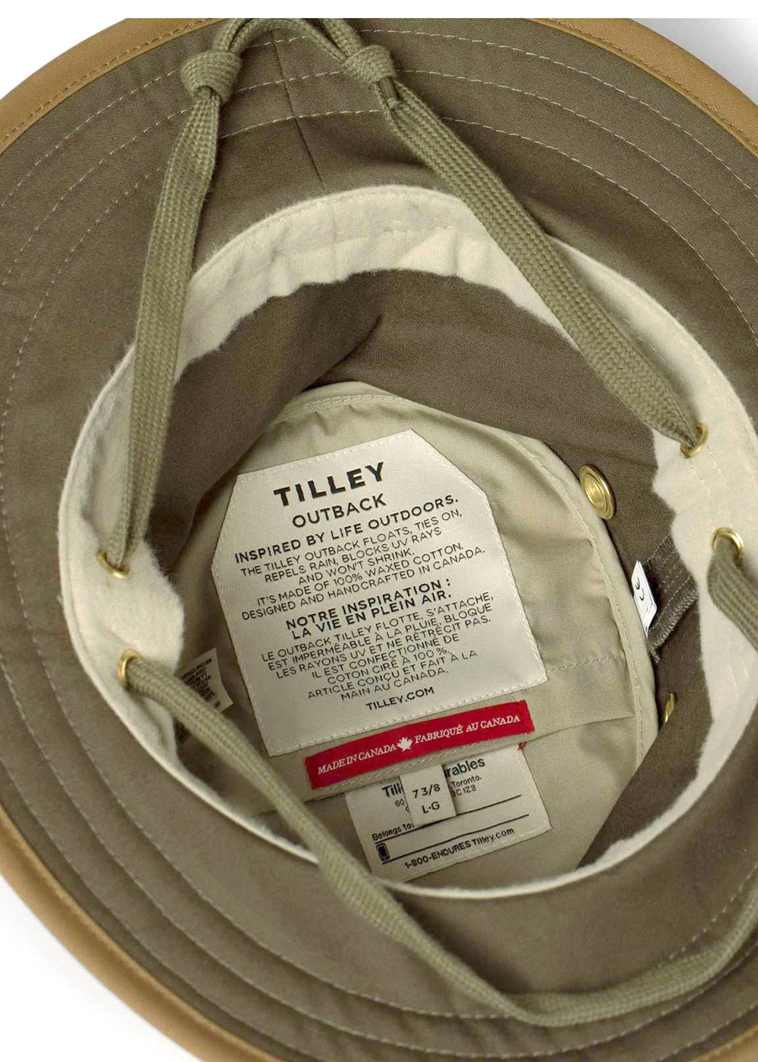 Close-up of the inside of a tan Tilley Outback hat showing the inner label with product details and fabric information.