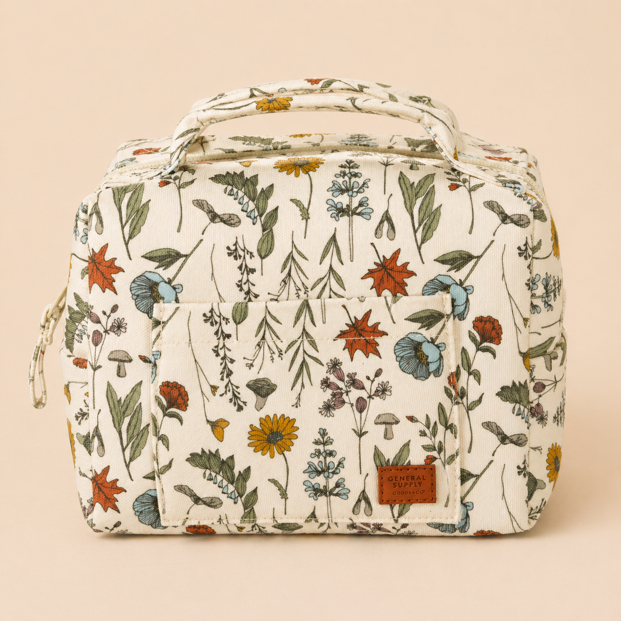 A white fabric backpack with a floral and mushroom print, featuring green, red, blue, yellow, and orange flowers and leaves. The front pocket has a leather patch with the text "GENERAL SUPPLY GOODS & CO."