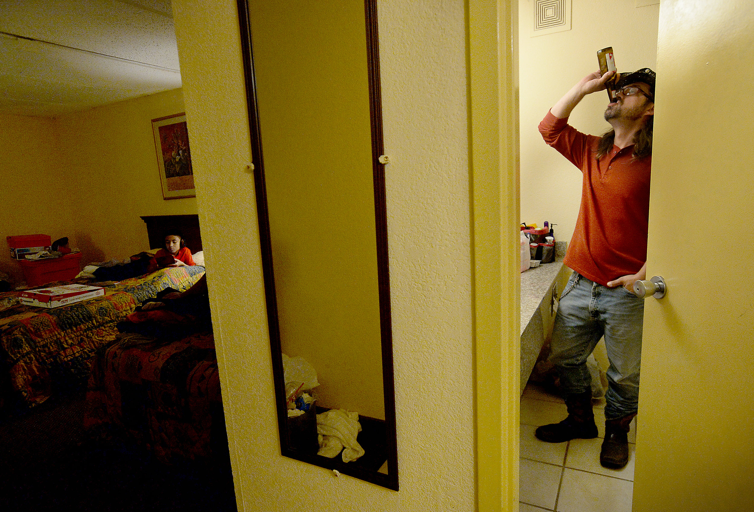  Steven Kaufman finishes a beer after stepping into the restroom to smoke at their hotel room in the Beaumont Lodge. The family have been staying there on a FEMA voucher after evacuating their flooded home 3 weeks ago.  Photo taken Wednesday, Septemb
