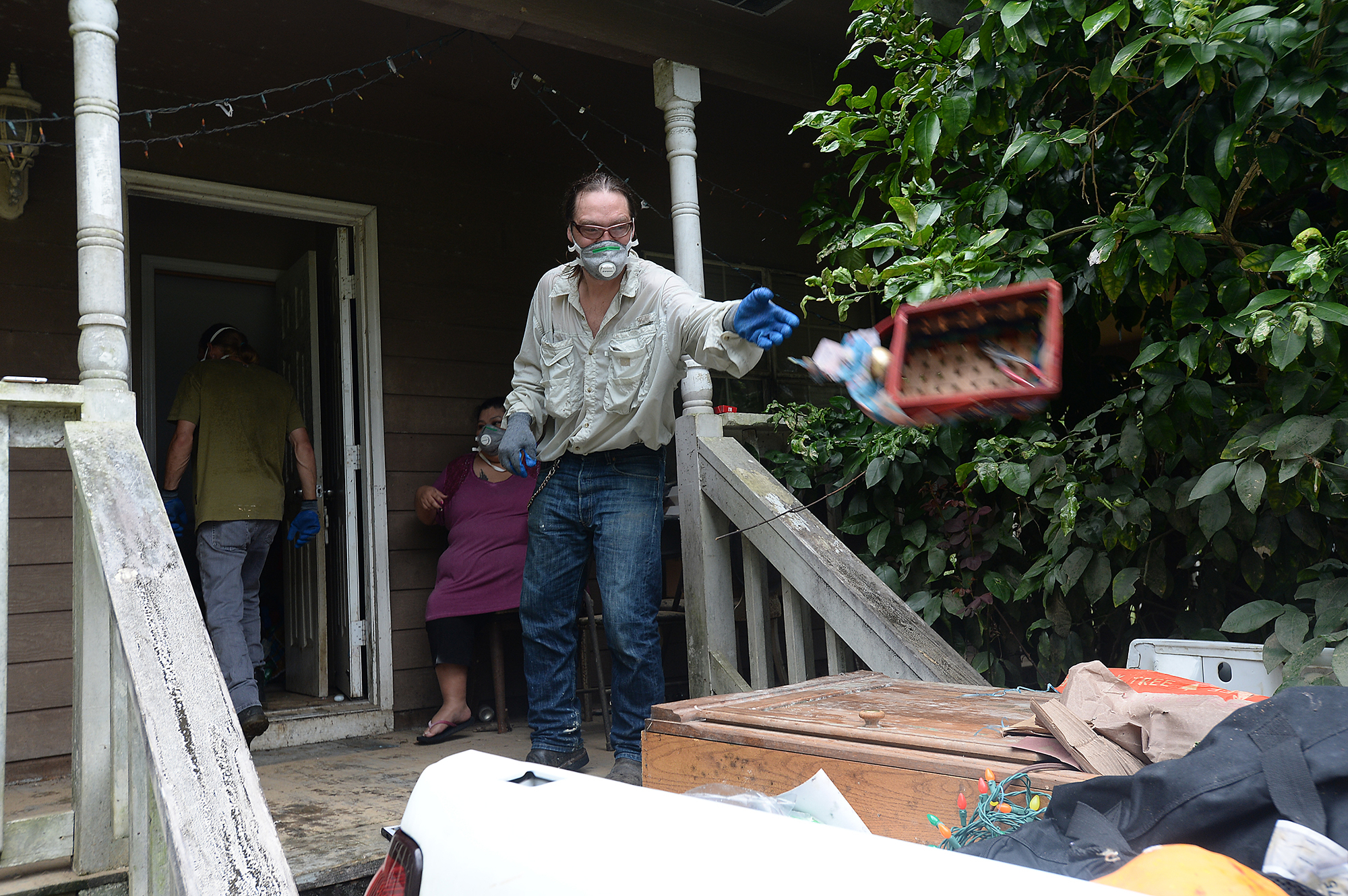  Steven Kaufman tosses another flood damaged item onto a growing pile in the bed of his pickup truck as Corey Mendes heads back in to pull out more debris from the Kaufman's residence on Mitchell Road in north Beaumont Wednesday. Mendes and wife Chri