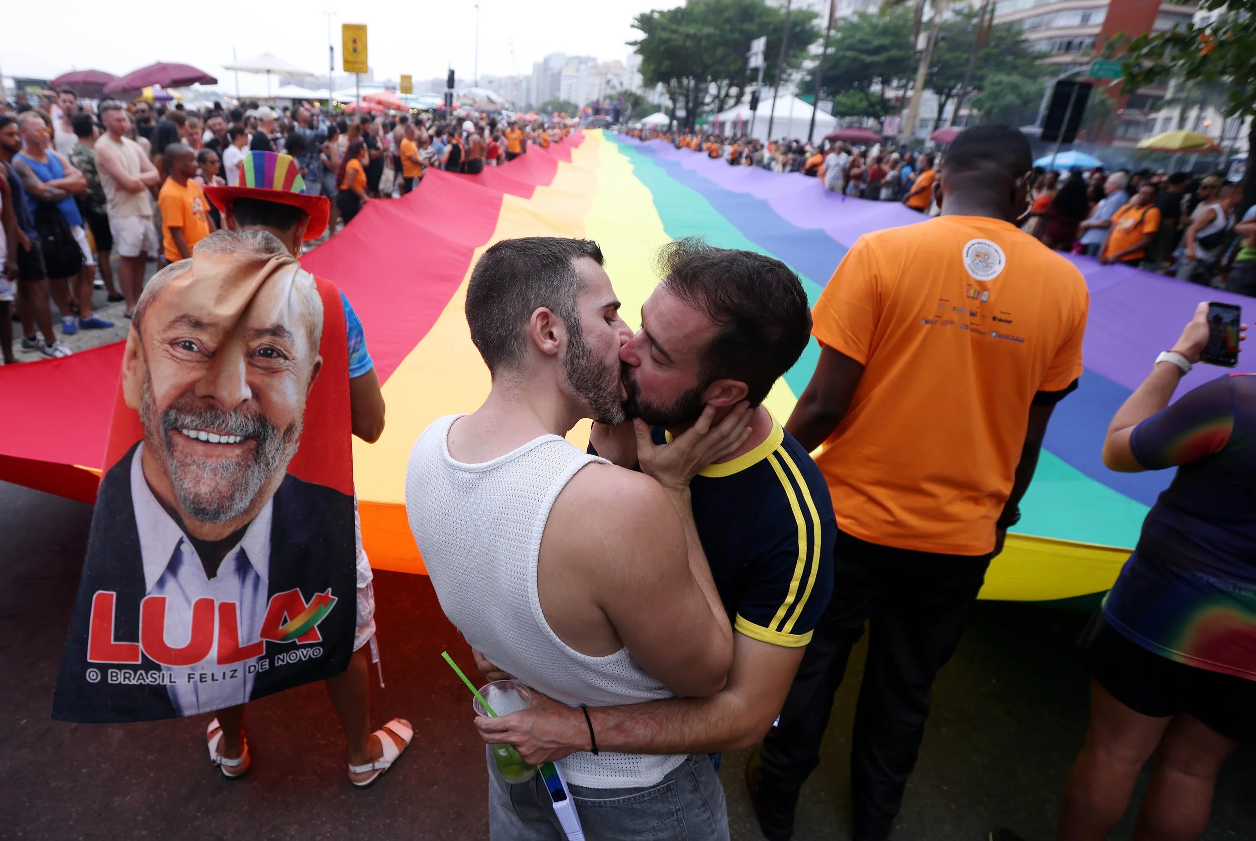 A couple kisses in front of a 430’ Pride flag during Rio de Janeiro’s iconic Pride Parade marking 30 years of LGBTI+ history with a powerful message of inclusion and sustainability. 