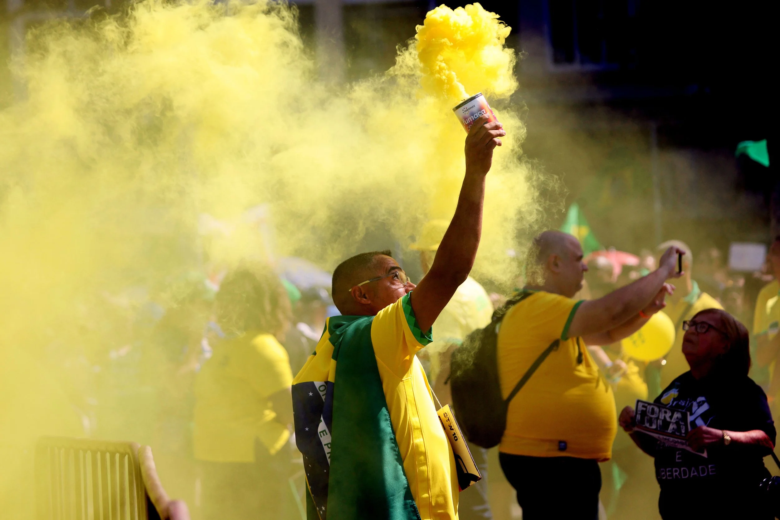 A man hold a yellow smoke bomb joining thousands of supporters of former Brazil President Jair Bolsonaro who gathered in Copacabana the ‘Reaja, Brasil’ protest