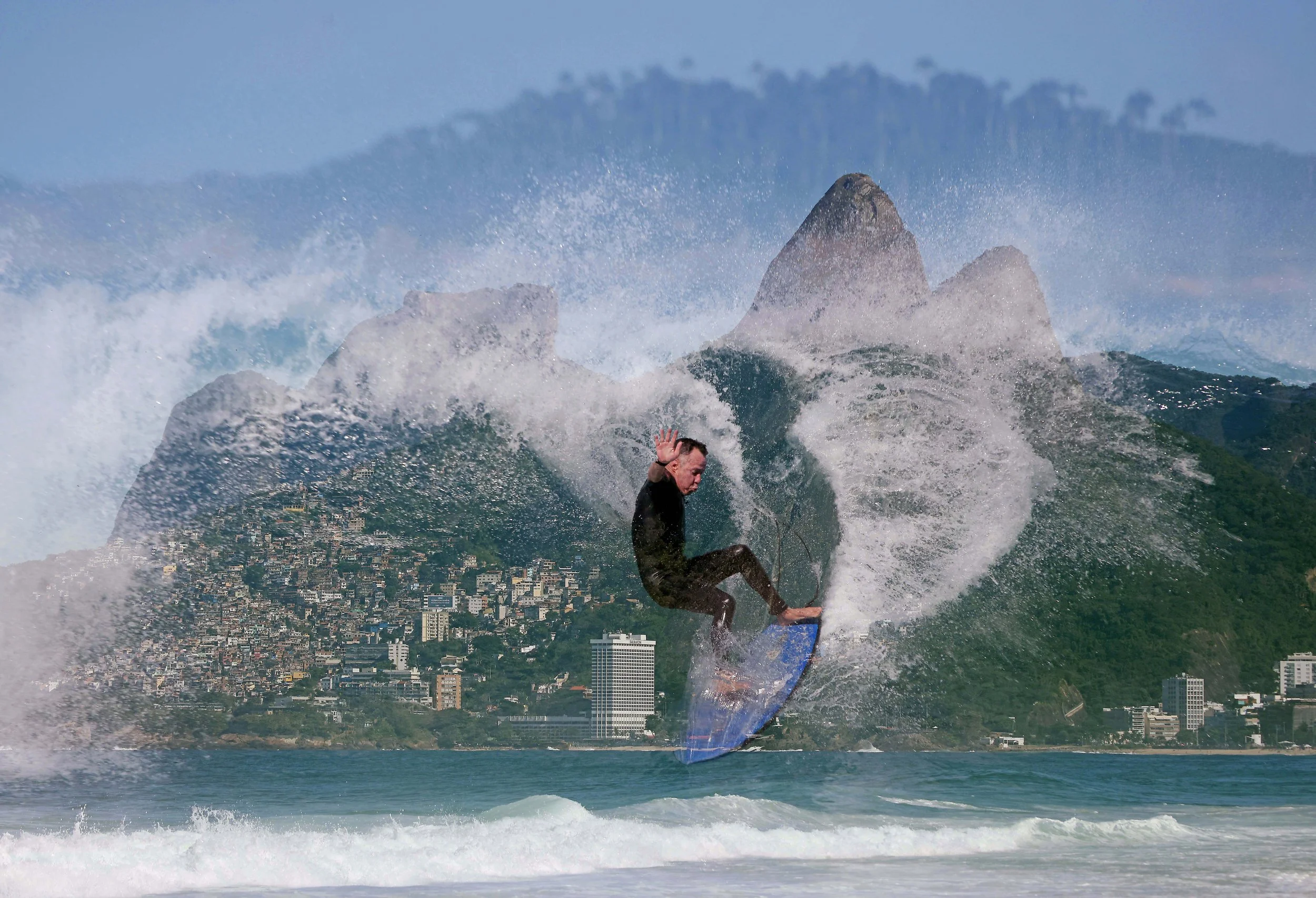 Surfer Rosaldo Cavalcanti rides a wave at Arpoador Beach in a in-camera double exposure with the iconic Dois Irmãos mountain in Rio de Janeiro, Brazil. 