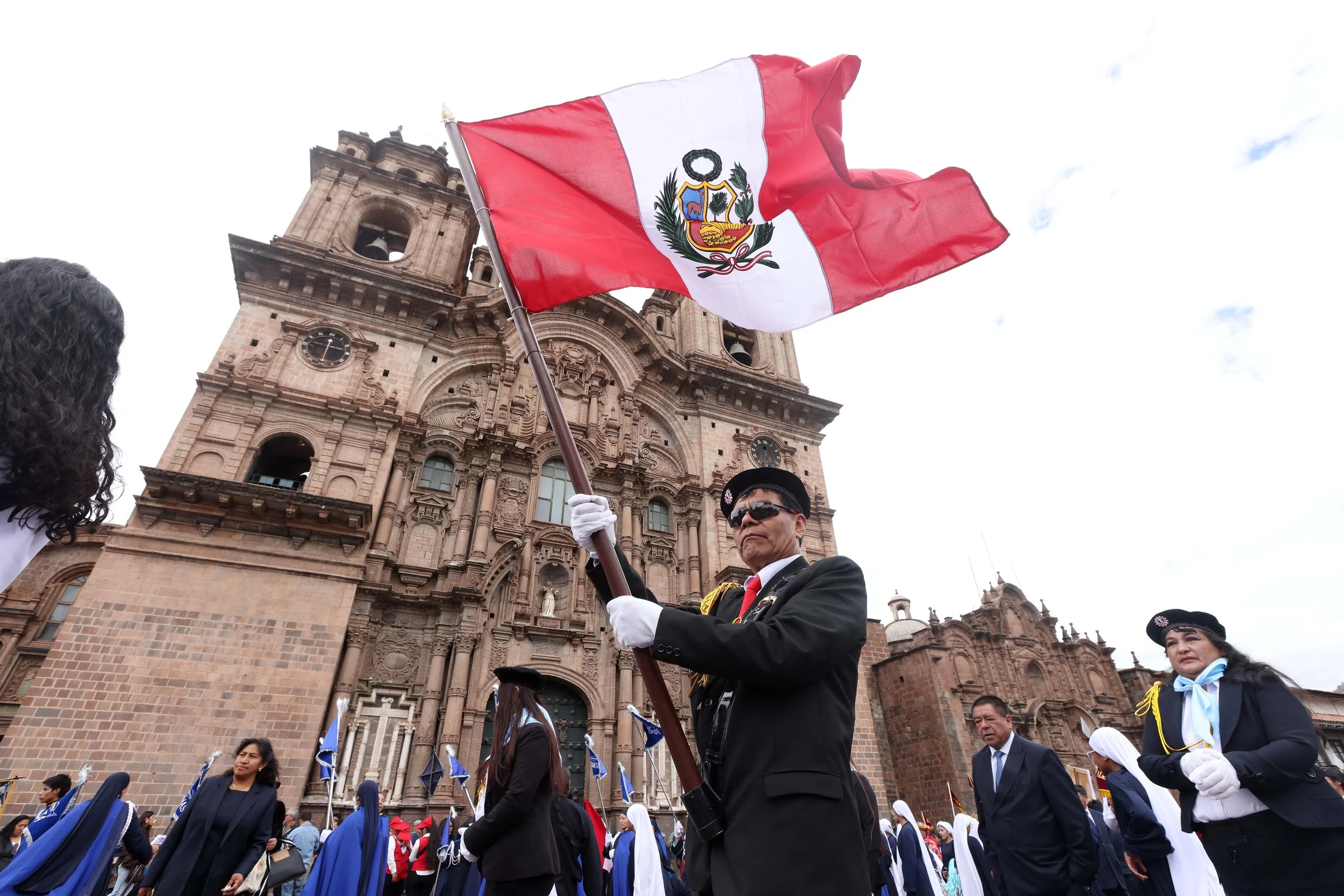A man carries the Peruvian flag during a procession in Cusco’s Plaza de Armas. Delegations from all 13 provinces of the Cusco region participated in a Grand Parade celebrating World Tourism Day.