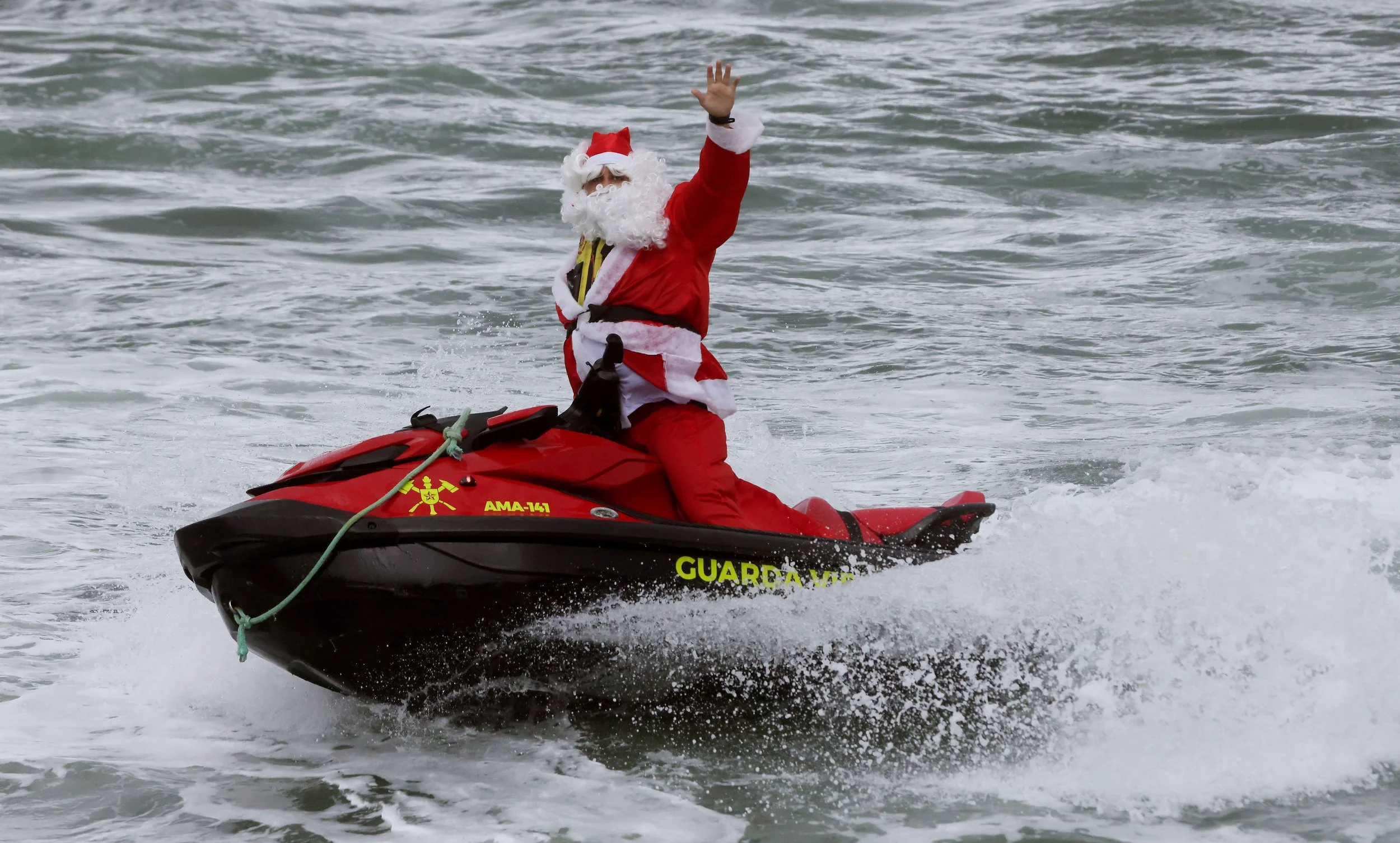A firefighter dressed as Santa Claus traded his sleigh for a jetski, arriving at Copacabana Beach in Rio de Janeiro to surprise children battling cancer, disabilities, and rare diseases