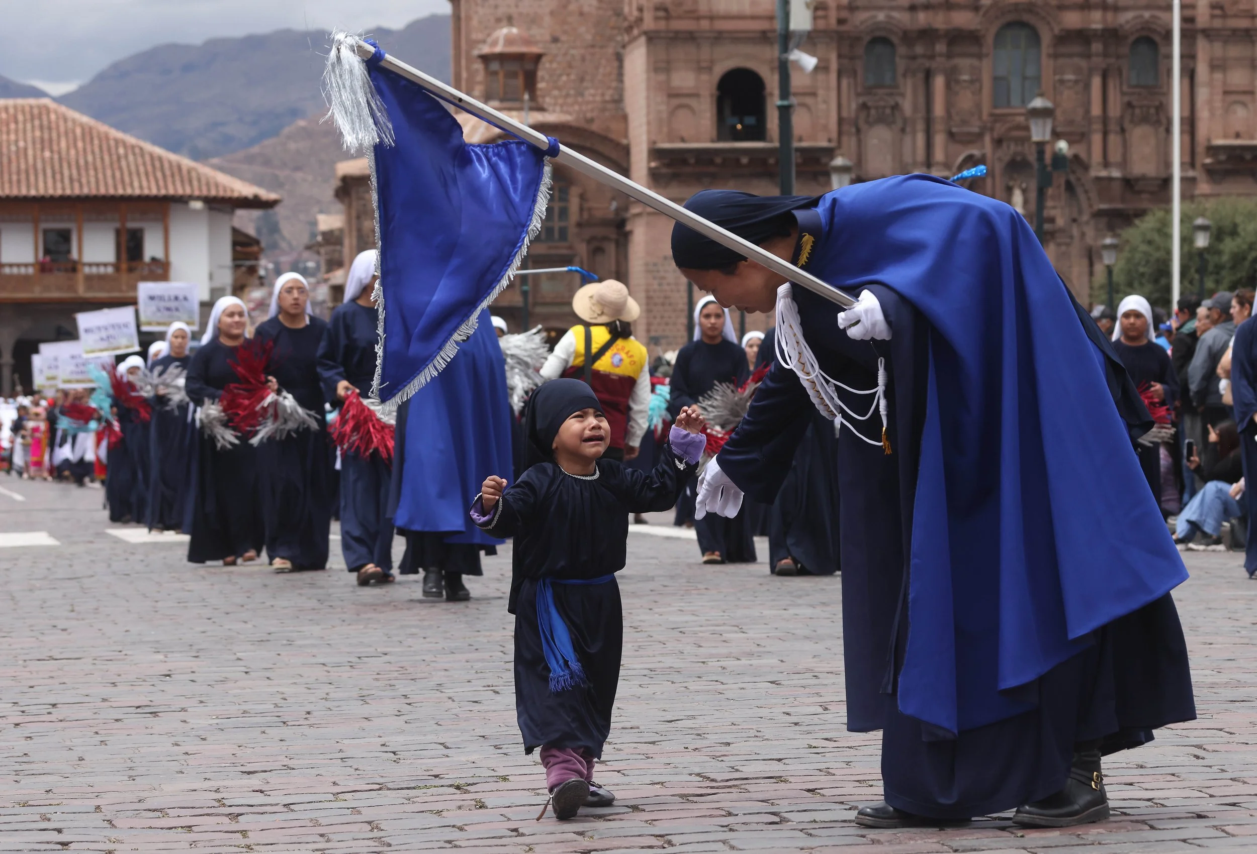 A child, tried to get his mother’s attention during a procession in Cusco’s Plaza de Armas. Without breaking stride, she reached down and scooped up her crying child.