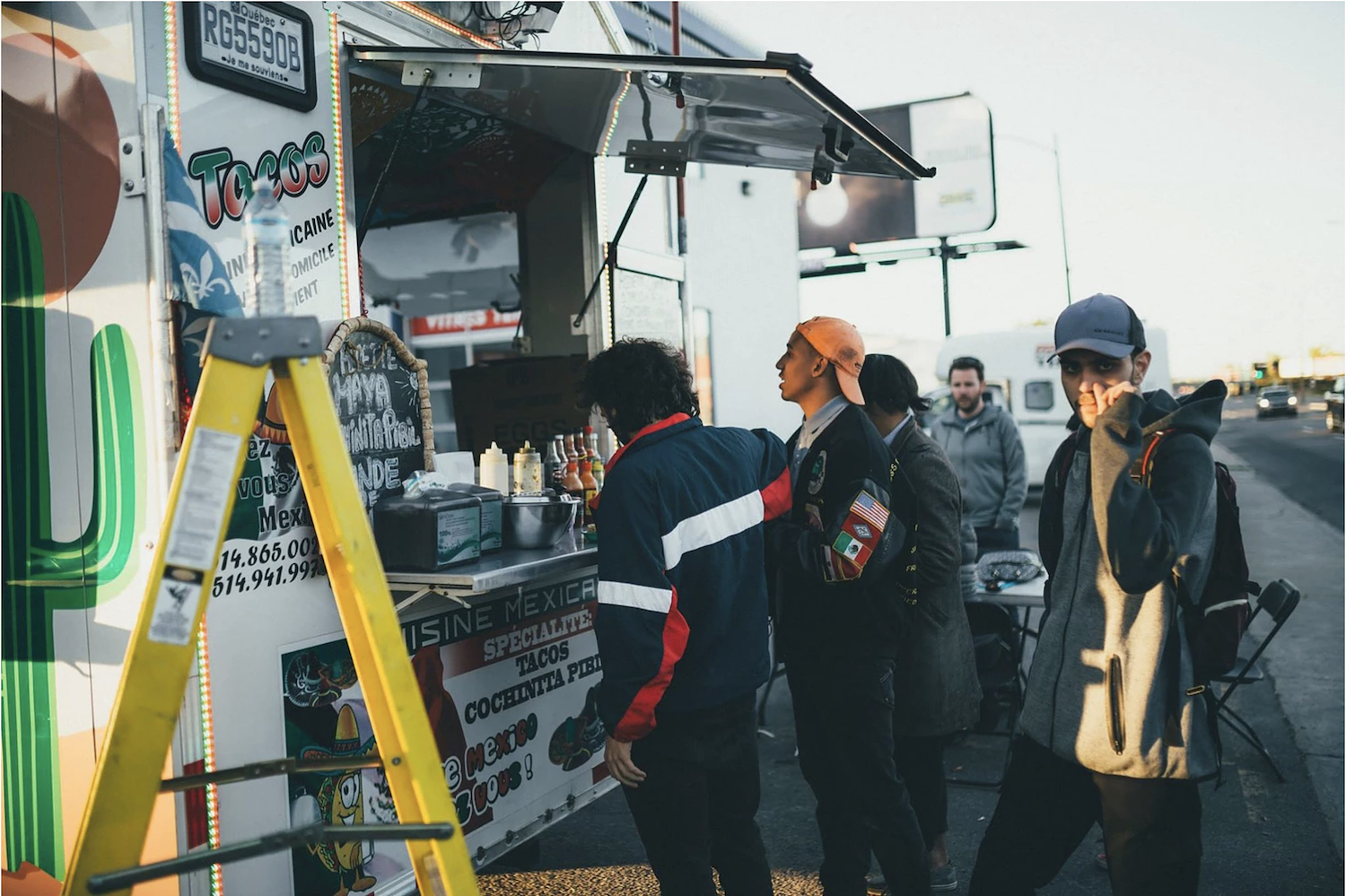 Members of KAJ and AdHoc stop shooting a music video to get tacos © Malik Issa