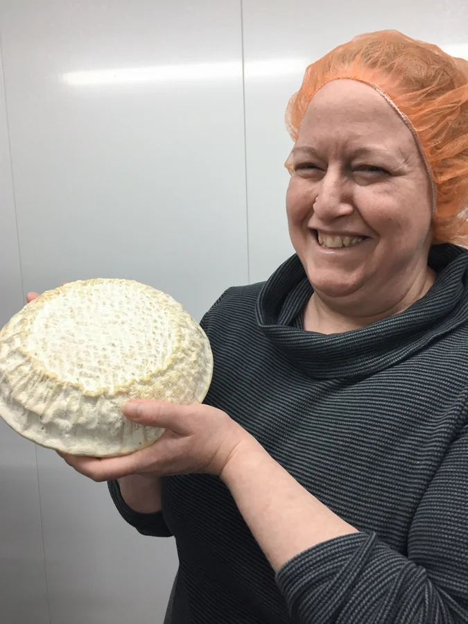Sarah in hairnet in one of the cleanest creameries I’ve been to, holding Carena wheel.