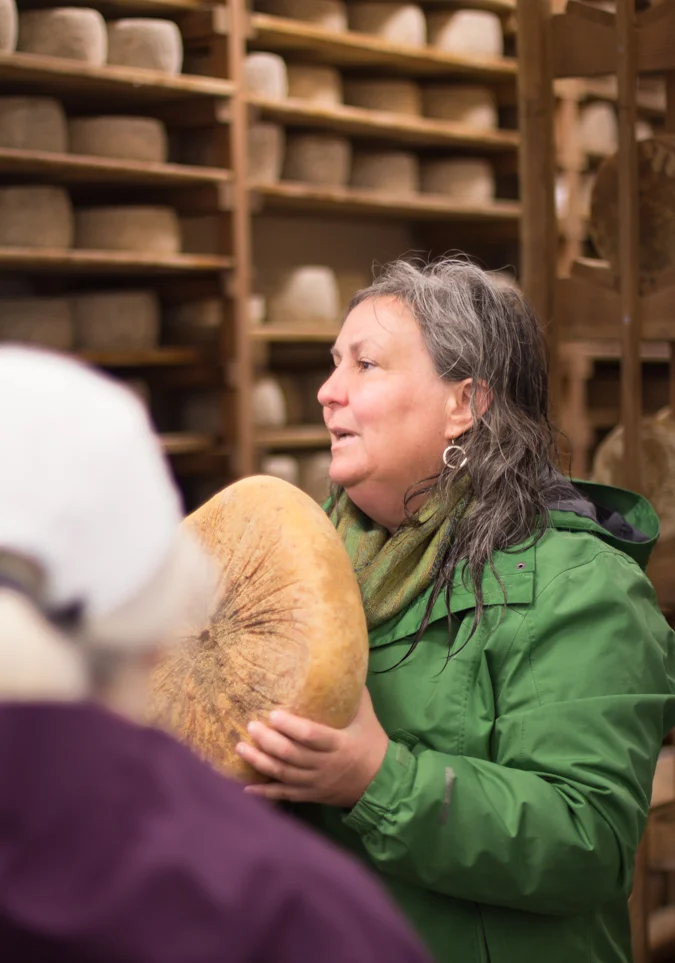 Cheesemaker Donna holding her Capricious, a spicy hard goat’s milk cheese beautiful shaved over grilled asparagus or drizzled with honey