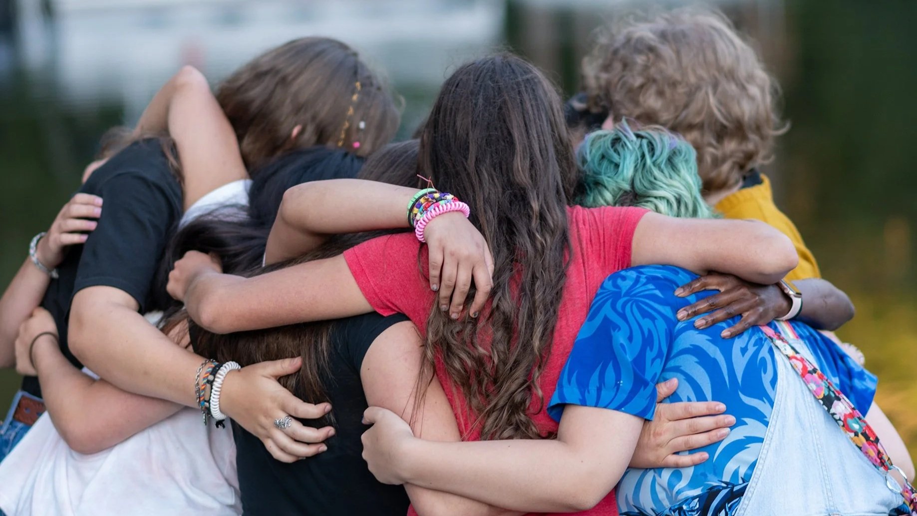A group of teen campers at Sunset Lake exchange a group hug as they prepare to head home after a life-changing week.