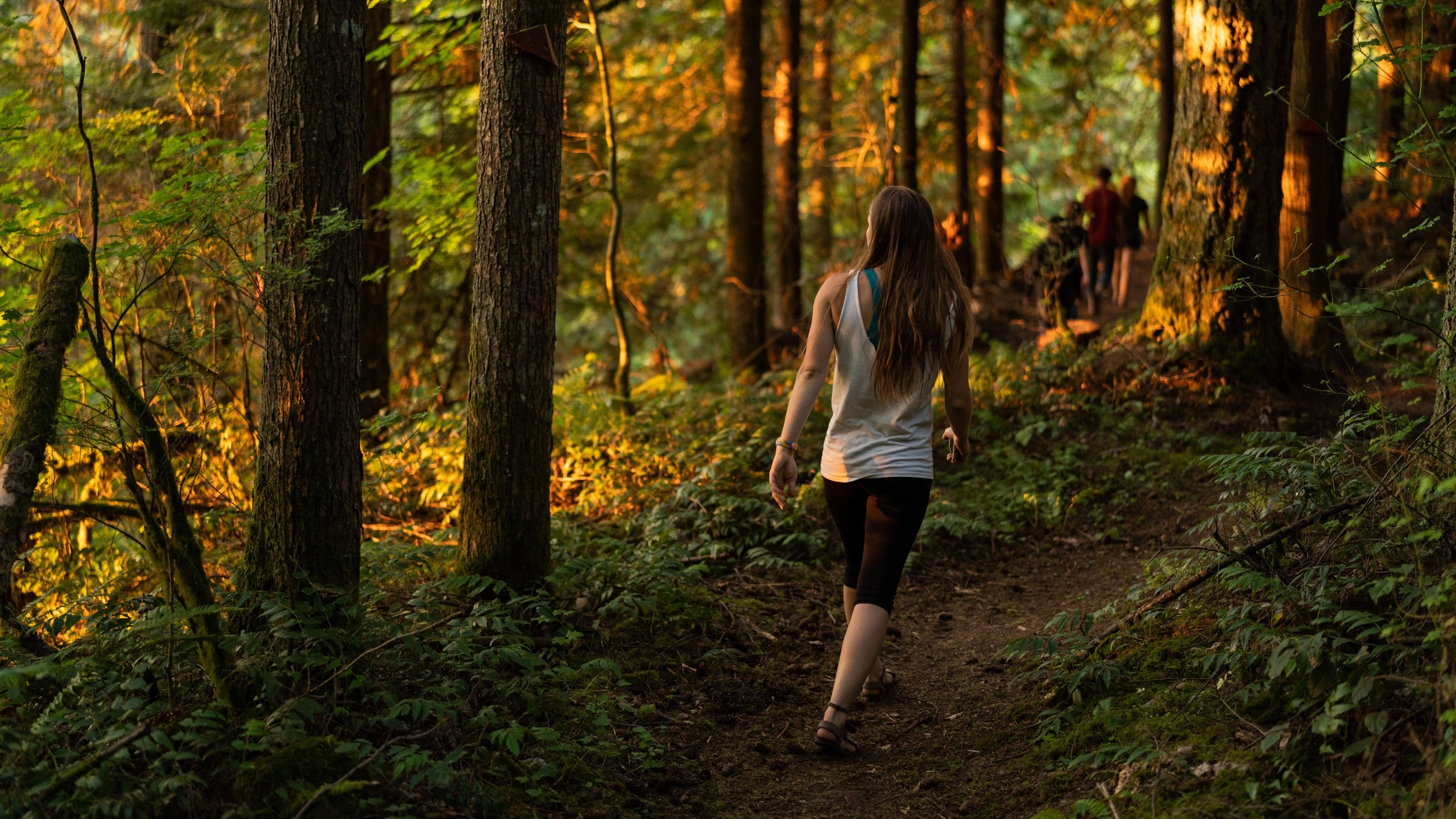 A small group of retreat guests walk the prayer path at Sunset Lake Camp.