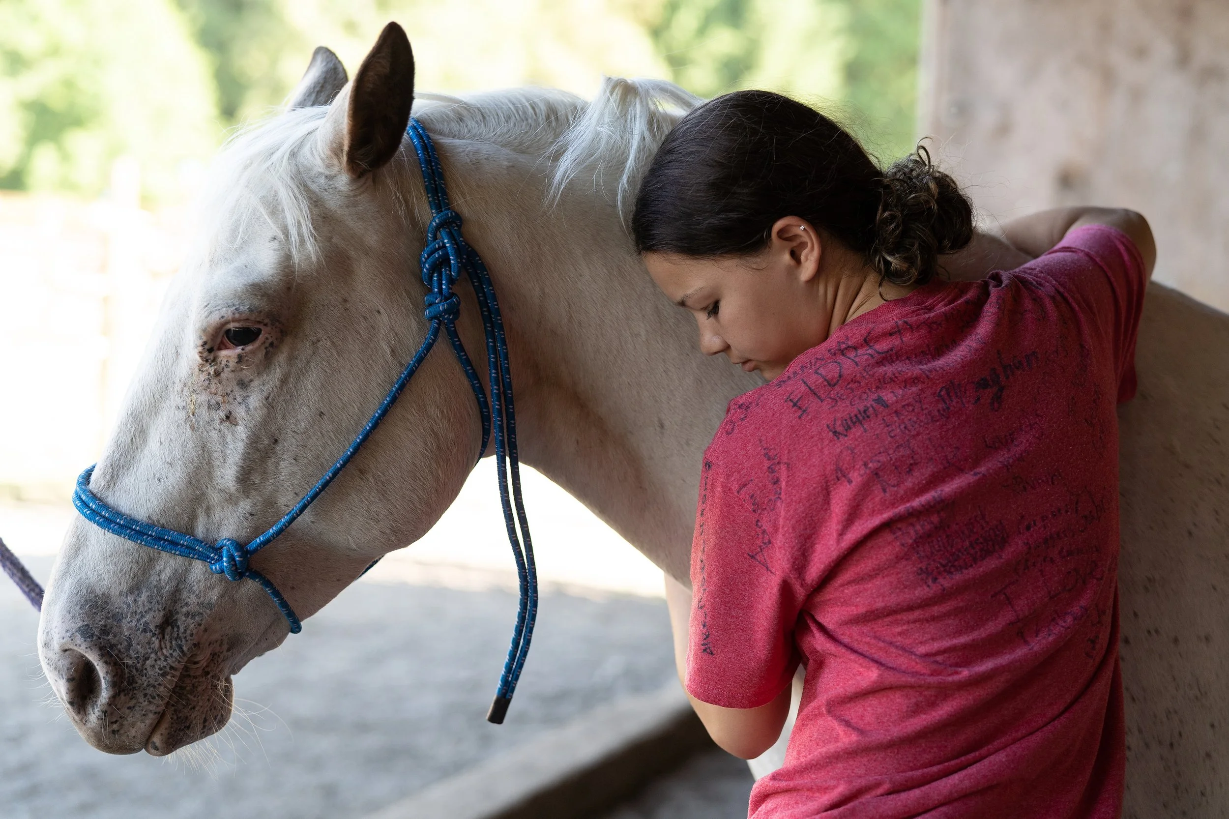 A girl connects with a horse at The Ranch at Sunset Lake..