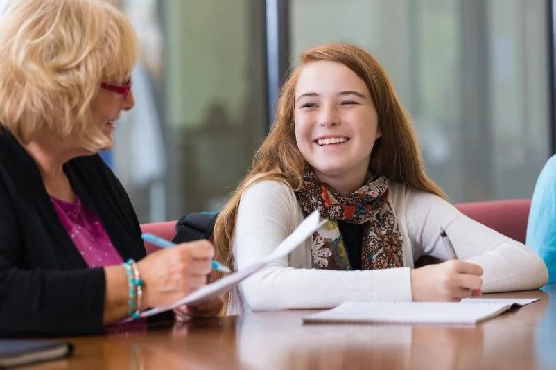 Student smiling with her teacher