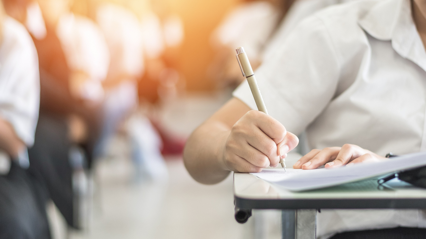 Exam-with-school-student-having-a-educational-test,-thinking-hard,-writing-answer-in-classroom-for--university-education-admission-and-world-literacy-day-concept-963192098_1368x769.jpeg