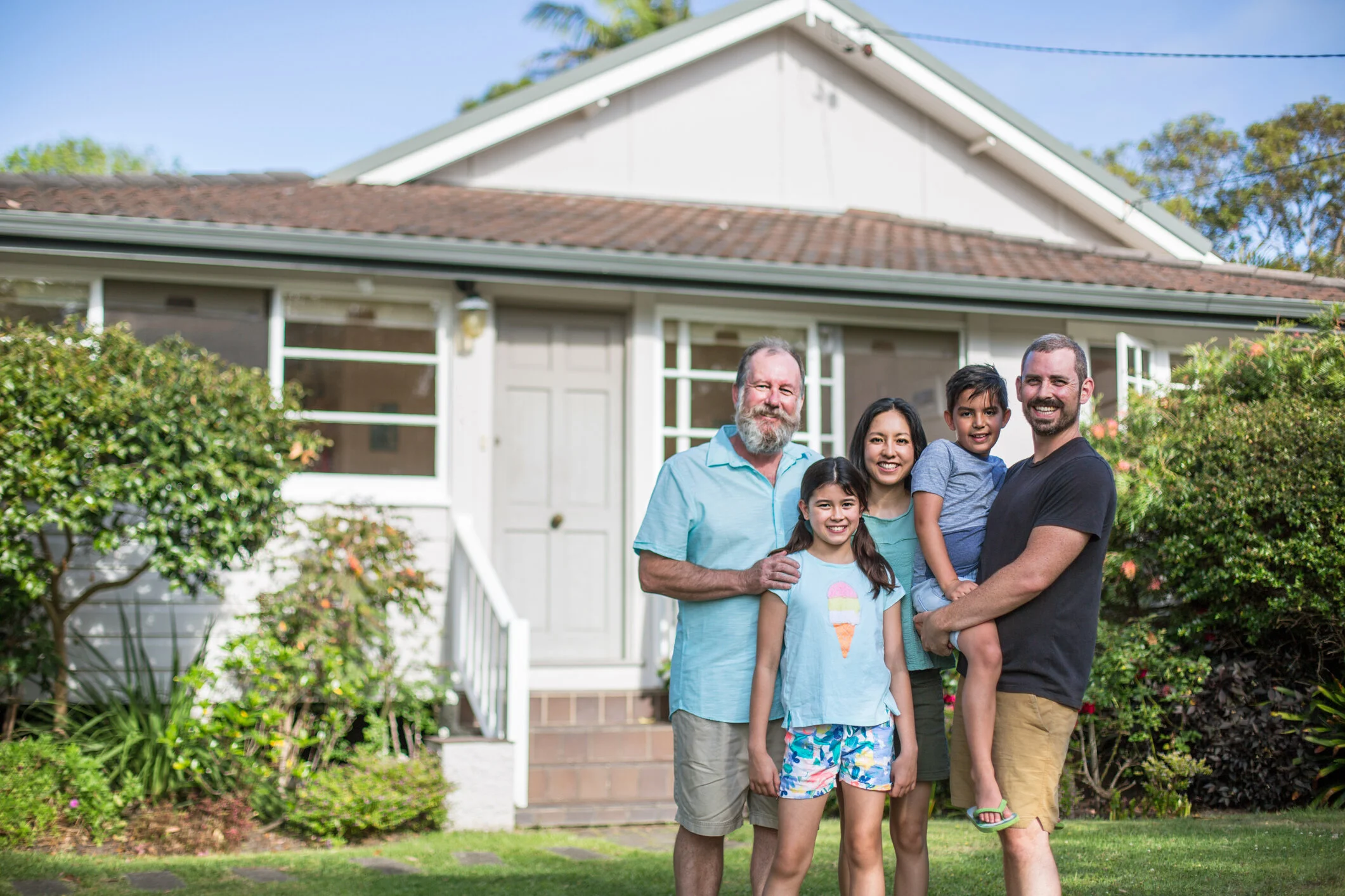 Portrait-of-smiling-family-standing-in-lawn-985596042_2125x1416.jpeg