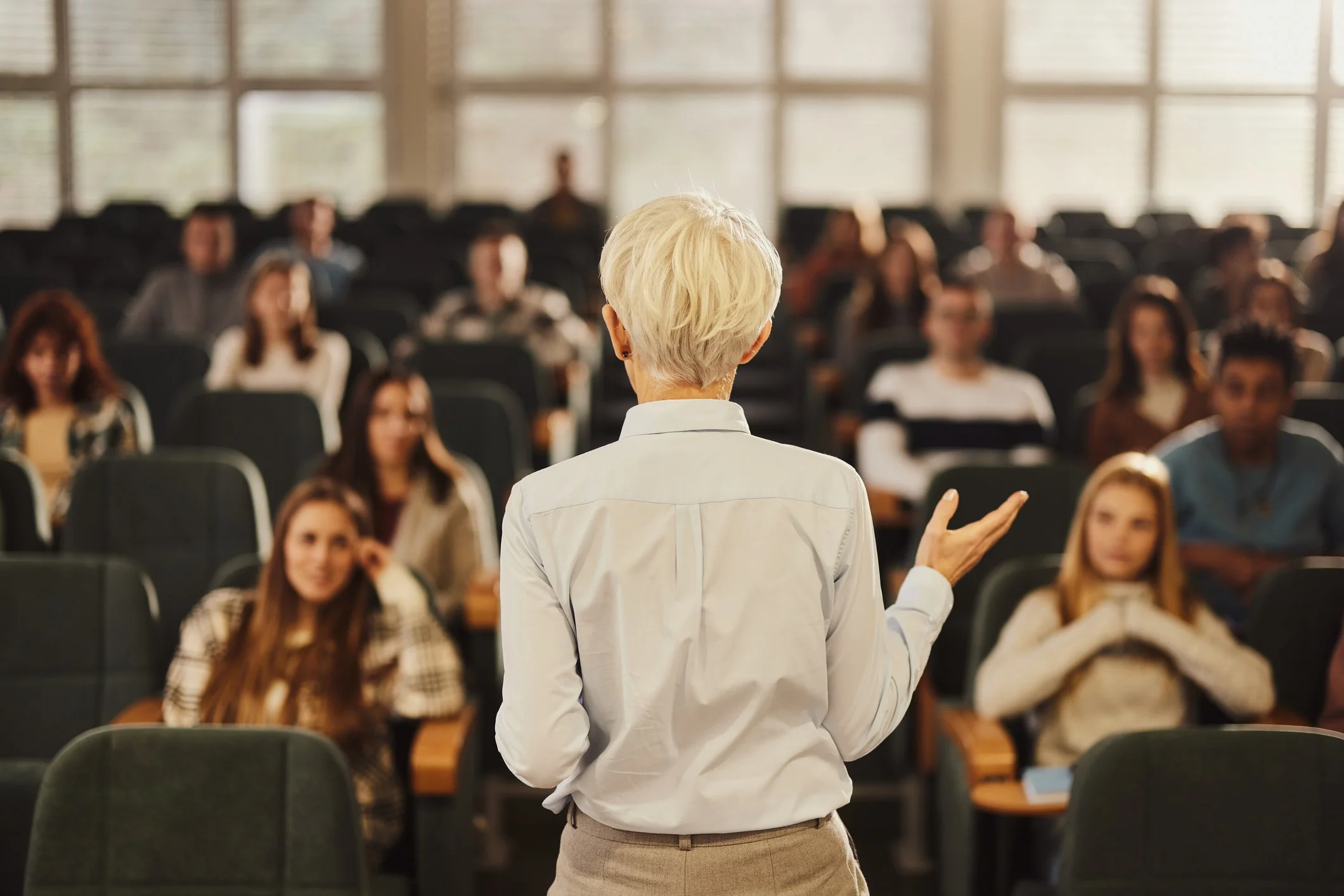 Back-view-of-a-female-professor-teaching-her-students-at-lecture-hall.-1456221352_2123x1416.jpeg