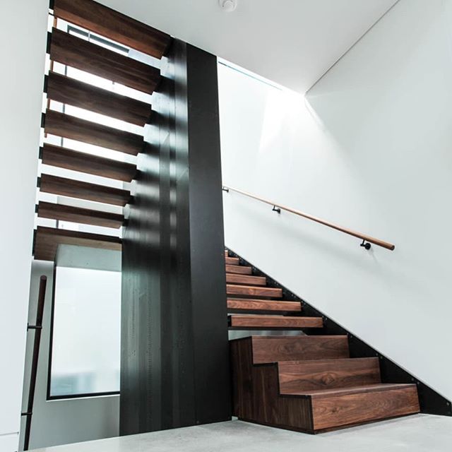Blackened steel and walnut residential stair. Central internally-lit monolith from basement to 2nd floor with stair wrapping around... millwork by @woodworkingtoronto design by @cindy_rendely_architexture #blackenedsteel #steelstair #stairporn #monol