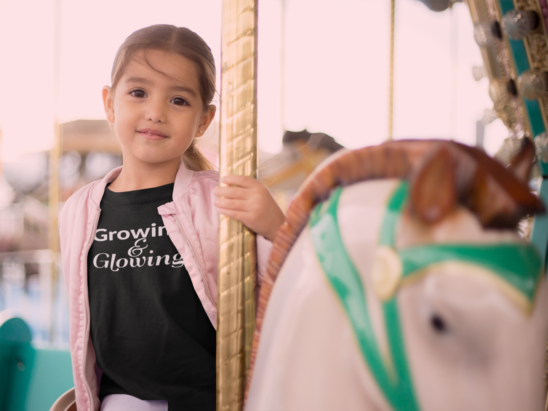mockup-of-a-little-girl-riding-a-carousel-horse-wearing-a-tshirt-and-a-pink-jacket-22527.png