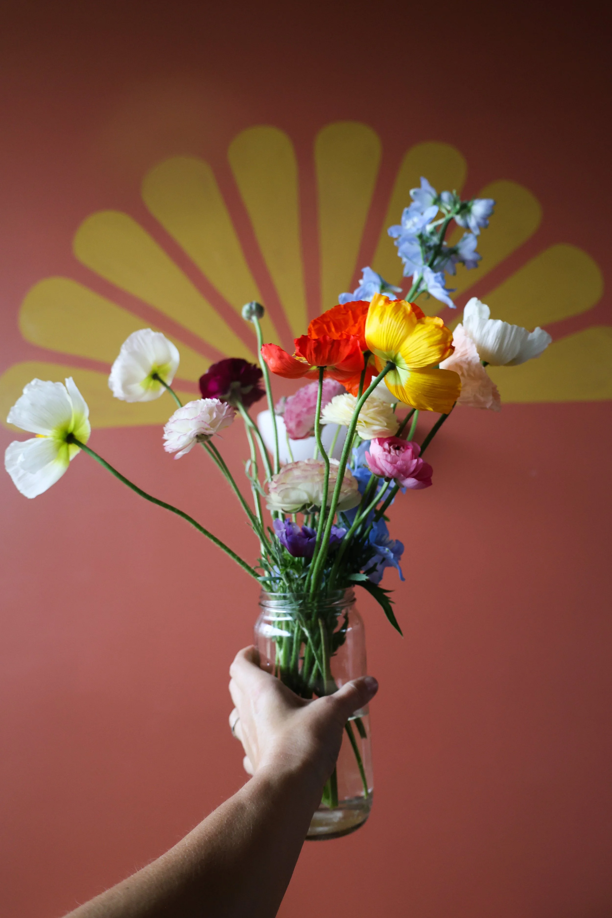 Local poppy flower bouquet with nourished folks logo in the background