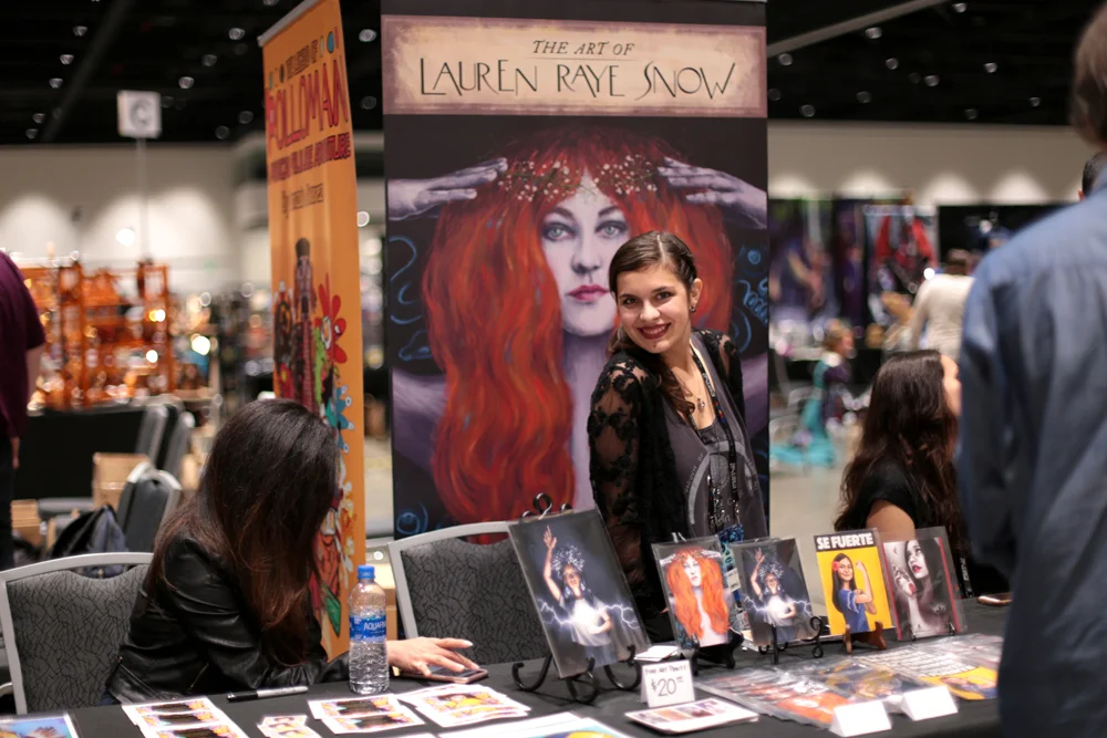 Lauren Raye Snow with a display of her art