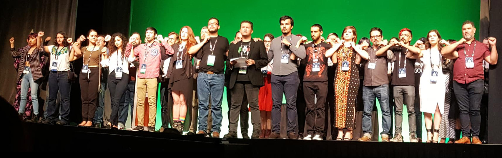 Full stage of Mexicanx Initiative members Xing up during the opening ceremonies at Worldcon 76 (Sent by John Picacio; photo by Debi Chowdhury)