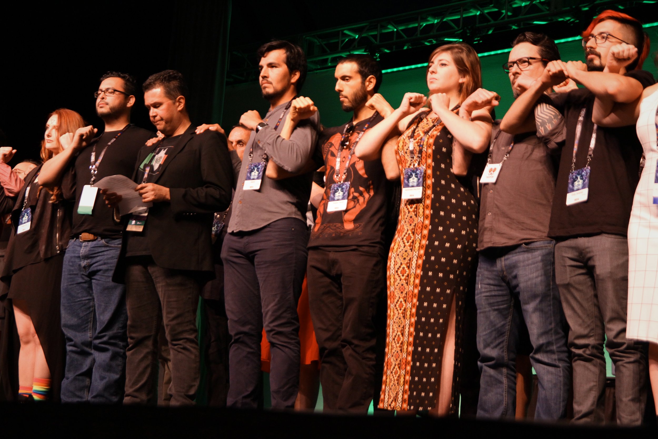 Mexicanx Initiative Participants standing in solidarity as John Picacio reads Lauren Snow's manifesto at Worldcon 76's opening ceremonies (Copyright 2018 Richard Canfield)