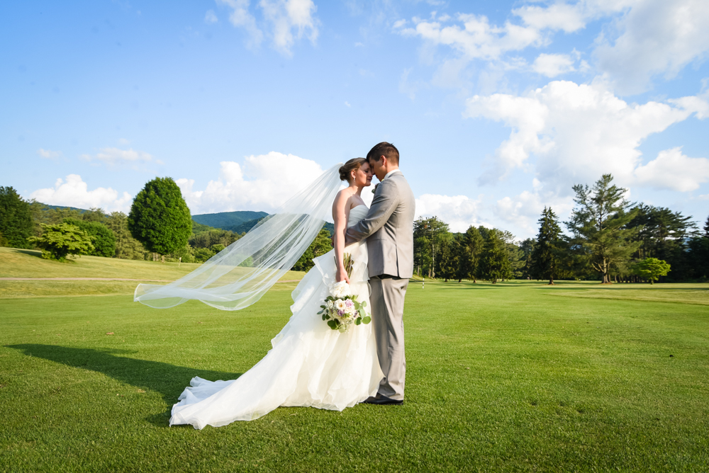 bride and groom facing each other photographed on golf course