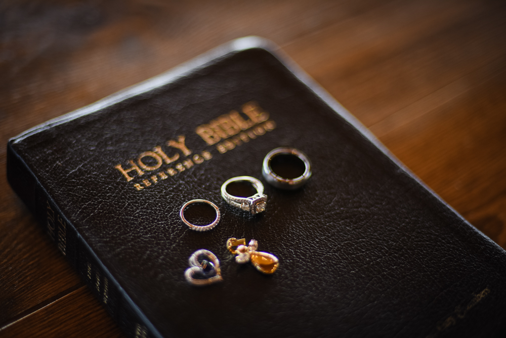 wedding rings and charms pictured on top of the Holy Bible