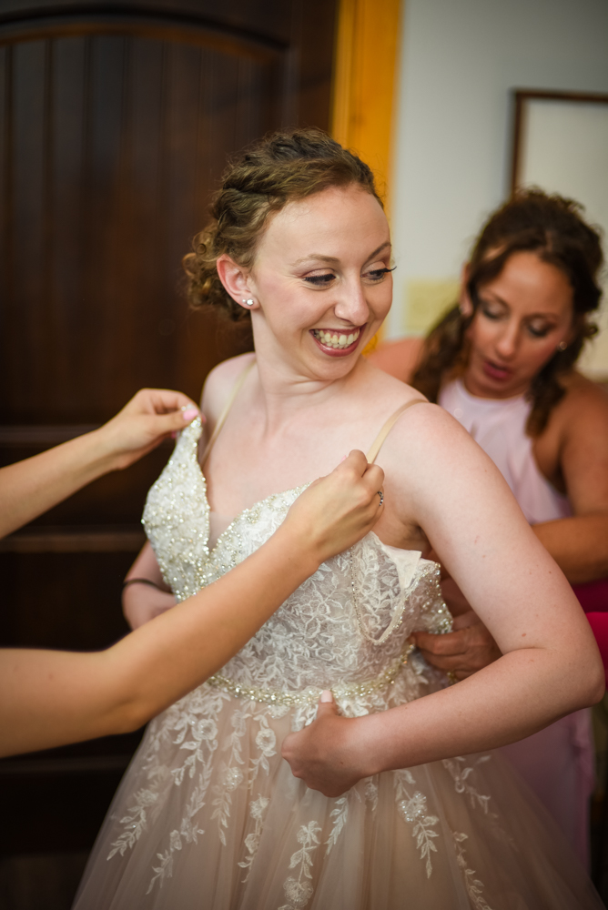 bride putting on wedding dress