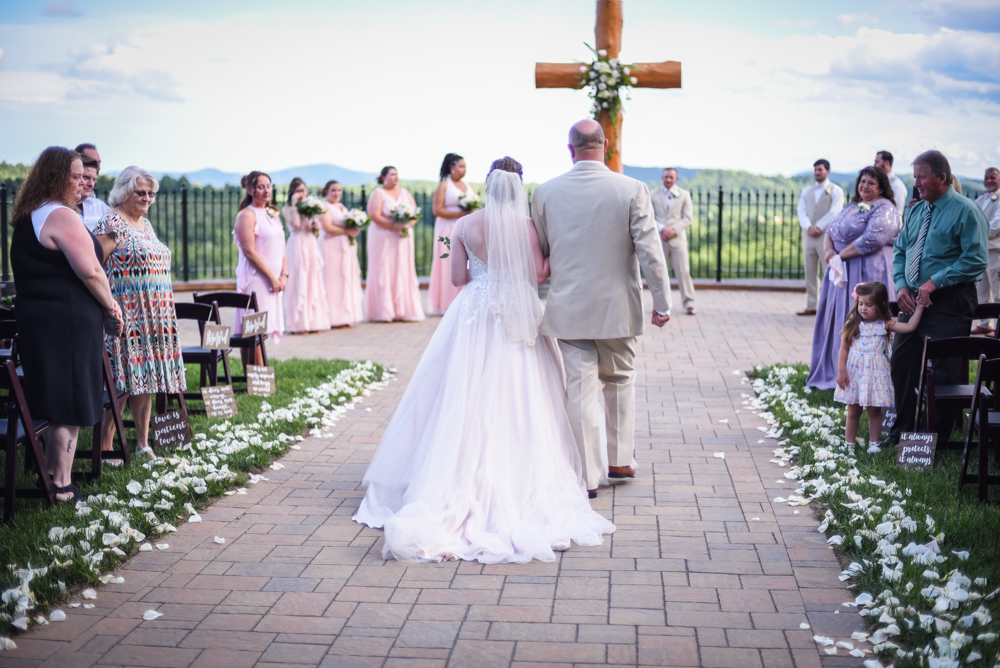 father of the bride walking the bride down the aisle at an outdoor wedding ceremony site at Point Lookout Vineyards