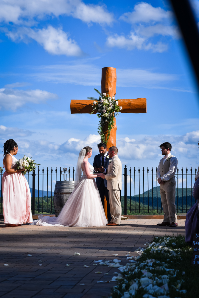 bride and groom exchanging vows during an outdoor wedding overlooking the mountains