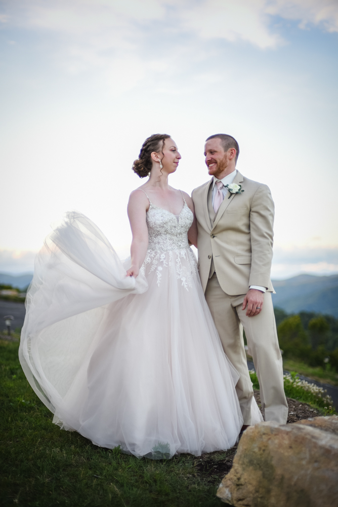 bride and groom smiling at each other with north carolina mountains in the background
